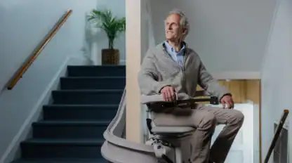 Older man rides a stairlift up stairs